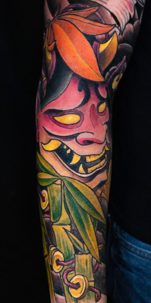 illustrative color Japanese color tattoo of a hannya mask with bamboo and Japanese maple leaves, done by Houston tattoo artist