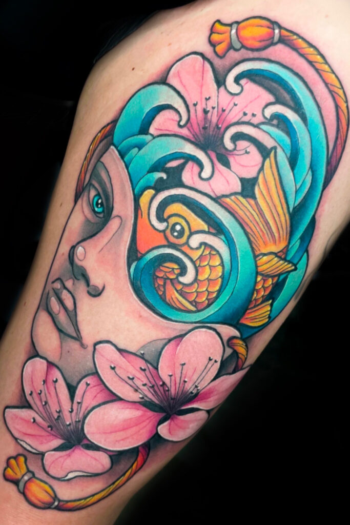 illustrative color tattoo of mask with a goldfish in the head with cherry blossoms scattered, done by Houston tattoo artist