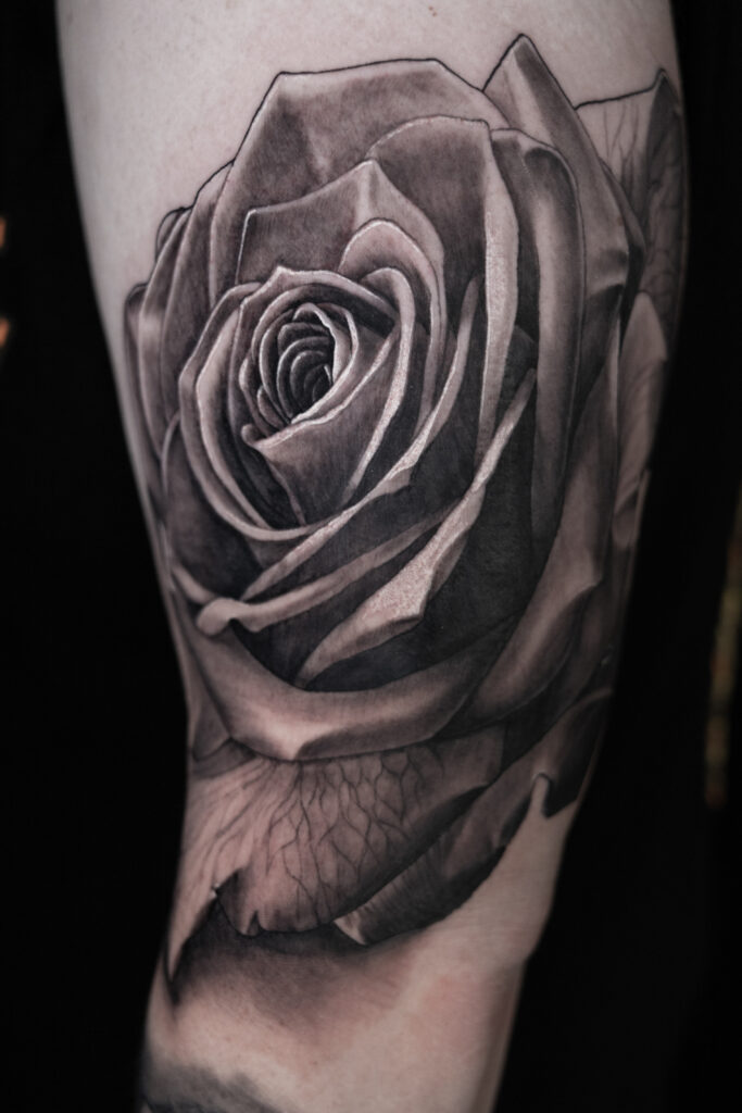 Large, extremely detailed of a black and grey rose tattoo as part of a sleeve. done by a Houston tattoo artist